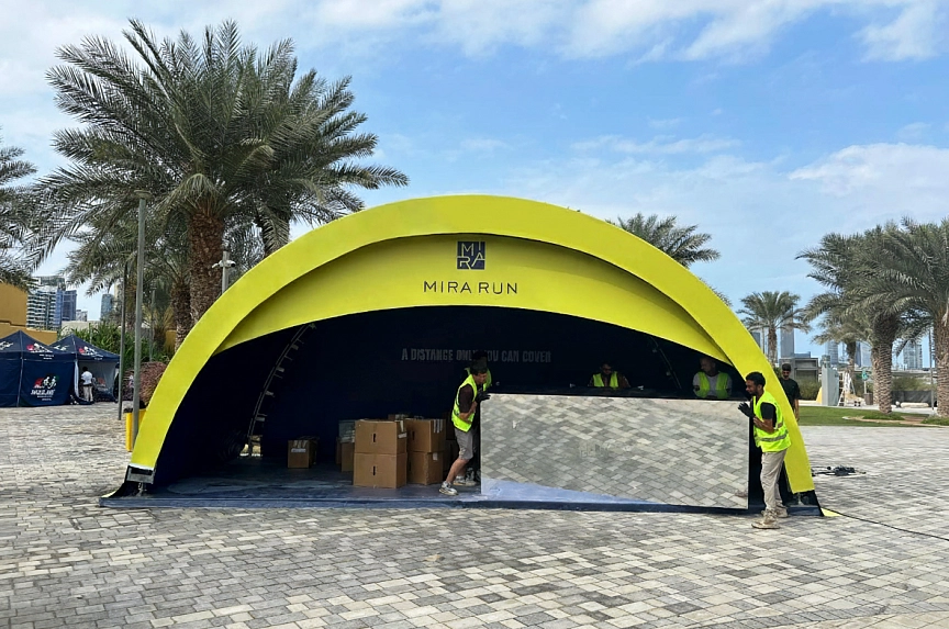 Custom branded modular arch entrance tent for Mira Run Dubai 2025 with yellow exterior, deep blue interior, participant registration area and fast setup on exhibition flooring in Dubai outdoor venue
