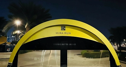 LED-illuminated modular arch event pavilion for Mira Run Dubai nighttime activation with strategic logo placement and wind-resistant structure amid palm trees